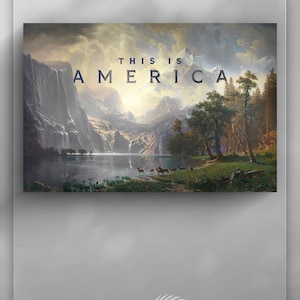 Pode incluir: Pintura de paisagem com um lago sereno rodeado por montanhas e árvores. A obra de arte apresenta um céu dramático com o texto "THIS IS AMERICA" em letras em negrito. Veados pastam perto da margem da água, realçando a cena natural.