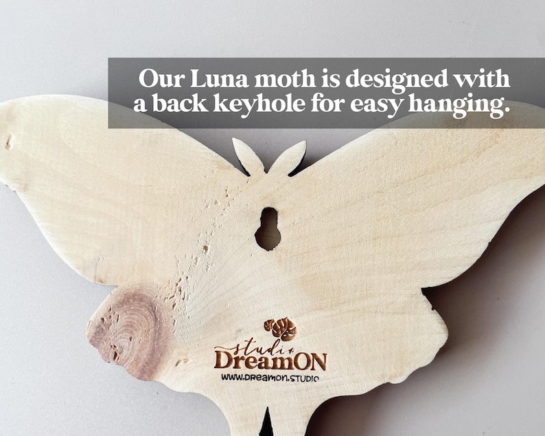 K&ouml;nnte beinhalten: Ein Wandbehang aus Holz in Form eines Luna-Nachtfalters mit einem Schl&uuml;sselloch auf der R&uuml;ckseite zum einfachen Aufh&auml;ngen. Der Falter ist hellbraun und hat eine nat&uuml;rliche Holzmaserung. Der Text "studi DreamON www.dreamon.STUDIO" ist auf der Unterseite des Falters aufgedruckt.