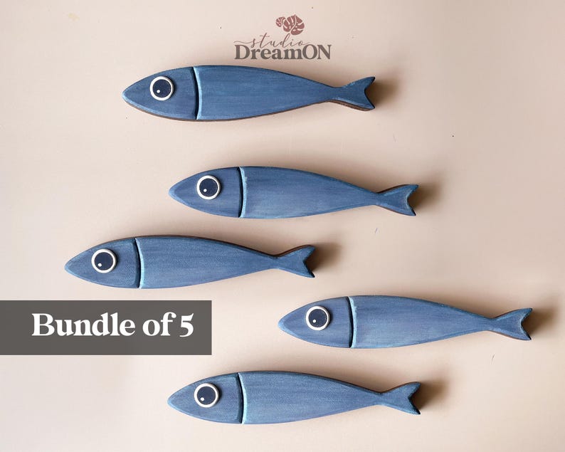 May include: Five blue wooden fish decorations with white and black eye details. The fish have a simple, stylized design and are arranged on a neutral background. The text "Bundle of 5" is displayed in a gray rectangle.