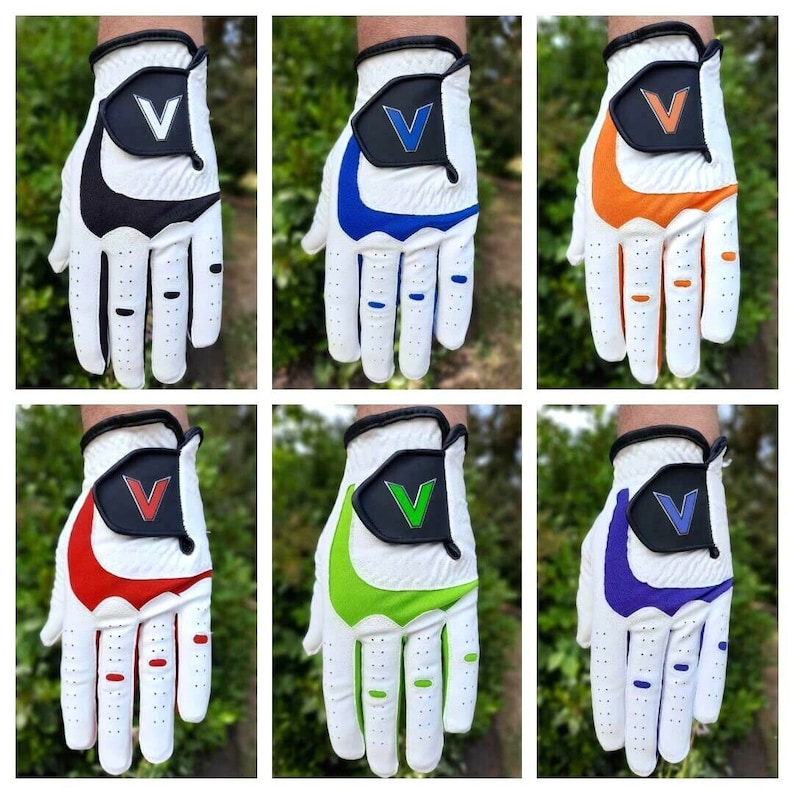 Op de afbeelding: Zes witte golfhandschoenen met verschillende gekleurde accenten. De handschoenen hebben een witte basis met een zwart, blauw, oranje, rood, groen of paars accent op de achterkant van de hand. Elke handschoen heeft een witte 'V' op het accent.
