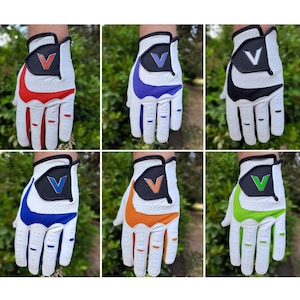 Puede incluir: Seis guantes de golf blancos con diferentes acentos de color. Los guantes tienen un logotipo V en la parte posterior de la mano. Los colores son rojo, azul, negro, naranja, verde y azul claro.