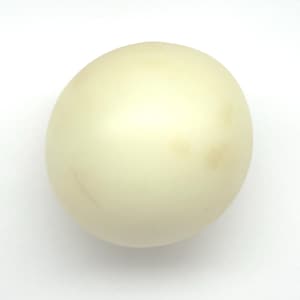 May include: A single, pale yellow egg with subtle brown marks. The egg is smooth and oval-shaped, set against a plain white background. The egg's colour is a creamy off-white.