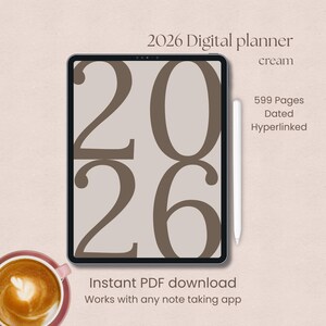 Pode incluir: Um planejador digital para 2026 exibido em um tablet. A tela mostra "2026" em marrom sobre um fundo creme. O texto inclui "cream", "599 Pages Dated Hyperlinked", "Instant PDF download" e "Works with any note taking app".