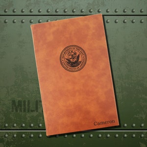 May include: A brown leather journal with the Department of the Navy seal and the name "Cameron" embossed on the front.