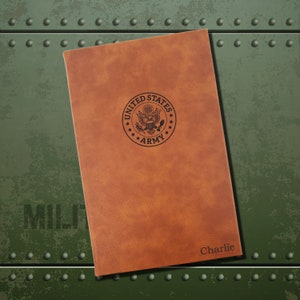 May include: A brown leather journal with the United States Army seal embossed on the front. The name "Charlie" is embossed on the bottom right corner.