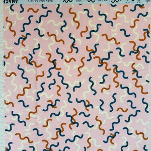 Può includere: Tessuto rosa con un motivo ripetitivo di linee ondulate in blu, bianco e arancione.