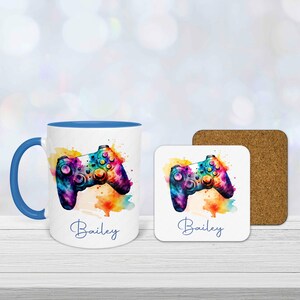 Personalised gamer mug and coaster set with colourful watercolour gaming controller design and custom name printed underneath.  Mug has a blue handle and is blue inside.