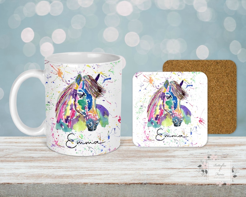 Puede incluir: Un juego de taza y posavasos de cer&aacute;mica blanca con una pintura acuarela colorida de la cabeza de un caballo. La taza y el posavasos est&aacute;n personalizados con el nombre "Emma" en escritura negra.