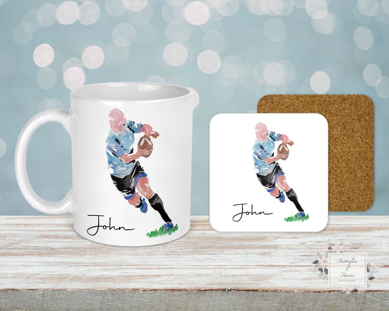 May include: White ceramic mug with a watercolor illustration of a rugby player running with the ball. The mug has the name "John" written on it.