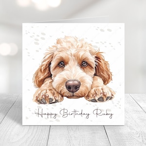 May include: A birthday card featuring a cute illustration of a light brown doodle dog with the text "Happy Birthday Ruby" on a white background.