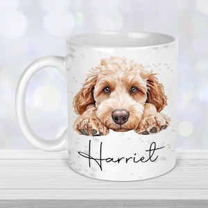 May include: White ceramic mug featuring a brown and white doodle of a dog with the name "Harriet" printed on the mug.