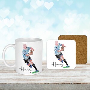 May include: White ceramic mug and coaster set with a watercolor illustration of a rugby player running with the ball. The mug and coaster are personalized with the name "Harry".