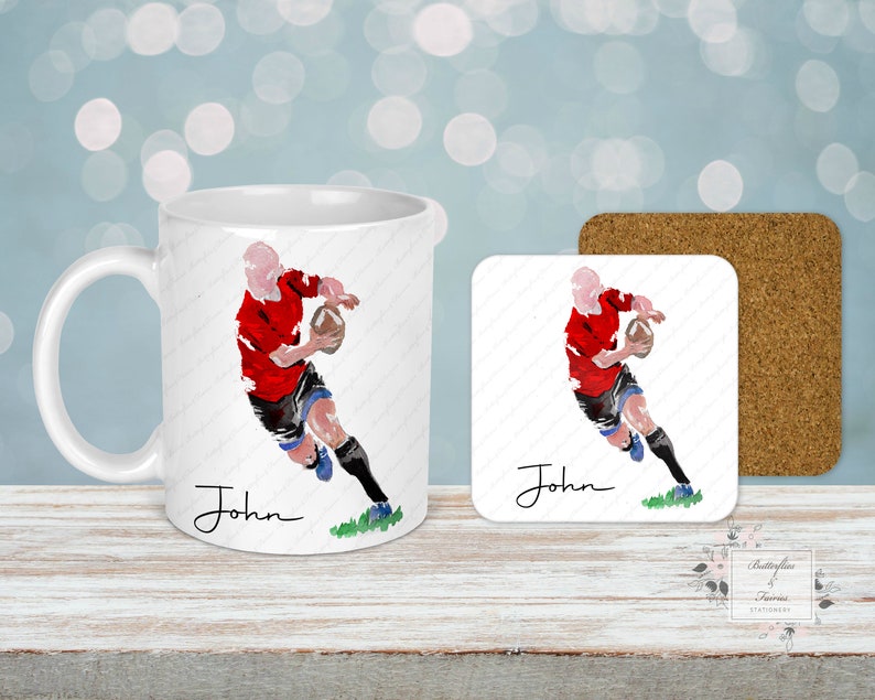 May include: A white ceramic mug and square coaster set featuring a watercolor illustration of a rugby player in a red jersey. The player is running with a football. The name "John" is written in cursive. A cork coaster is also included.