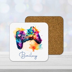 Personalised gamer coaster with colourful watercolour gaming controller design and custom name printed underneath.