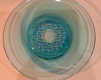 May include: A light blue glass bowl with a raised, circular pattern on the bottom.