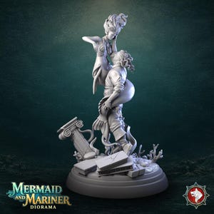 May include: A detailed grey diorama sculpture of a mermaid and mariner in an embrace. The sculpture includes a broken column, coral, and the text "Mermaid and Mariner Diorama". It is set on a round base.