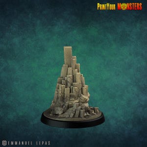 Peut inclure: Une figurine de terrain beige détaillée, ressemblant à une montagne rocheuse ou à une falaise. La base est un cercle noir. Le texte "PrintYourMonsters" est visible en haut à droite. Idéal pour les jeux de table.