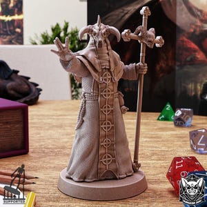 Könnte beinhalten: Beigefarbene Figur einer gehörnten, skelettartigen Figur in einer Robe, die einen Stab mit einem schädelförmigen Oberteil hält. Die Figur steht auf einem kreisförmigen Sockel. Das Bild enthält Würfel und den Text "SUPPORTED" und "DUNGEON DOG".