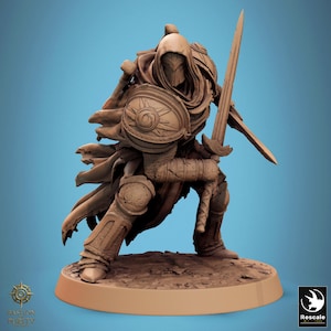 Könnte beinhalten: Detaillierte Figur eines Kriegers in einer Kapuzenrobe, kniend mit Schwert und Schild. Das Schild zeigt ein Sonnenmuster. Die Figur befindet sich in einer kampfbereiten Pose mit komplizierten Rüstungsdetails.