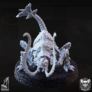 May include: A light gray, detailed miniature creature with a segmented body, multiple limbs, and a long, curved neck. The creature has a textured, rocky appearance and is mounted on a black, circular base. The design is intricate and appears to be a fantasy or sci-fi themed model.