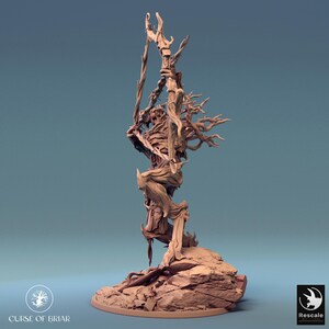 May include: A detailed, hand-painted miniature of a creature made of wood and branches, holding a bow and arrow. The creature is standing on a rocky base. The miniature is painted in shades of brown and beige.