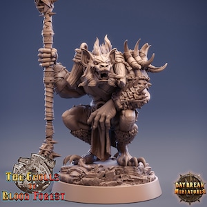 May include: A detailed miniature of a snarling, brown gnoll with a staff, wearing armor and a loincloth. The gnoll is standing on a rocky base. The miniature is part of the "The Gnolls of Blood Forest" collection by Daybreak Miniatures.