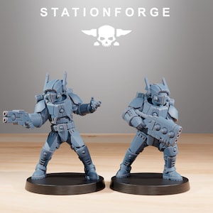 Könnte beinhalten: Zwei graue Miniatur-Soldatenfiguren auf schwarzen runden Sockeln. Jede Figur trägt eine futuristische Rüstung mit einem Helm mit seitlichen Finnen und hält eine schwere Blasterwaffe. Der Text STATIONFORGE und ein Totenkopf-Logo sind darüber zu sehen.