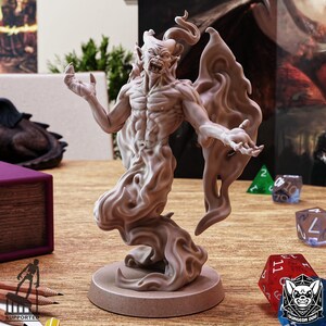 Op de afbeelding: Een 3D-geprint miniatuur van een demon met vleugels, staand op een ronde basis. De demon is gebeeldhouwd in een lichtbruine kleur en heeft een dreigende uitdrukking.