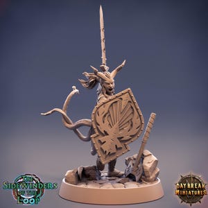 Può includere: Statuetta dettagliata di un guerriero fantasy con corna, che tiene uno scudo e una spada. Lo scudo ha la forma di un picche con un design stilizzato. Il guerriero è su una base rocciosa, con un'arma ai suoi piedi. La statuetta è di colore marrone chiaro.