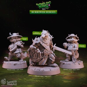 May include: Three grey resin miniature figures titled Woodland Heroes 965 Burrower Heroes. The set includes a Raccoon Bard with a lute, a Badger Barbarian with a sword and shield, and a Raccoon Farmer with a shovel. Heights are 29mm and 35mm.
