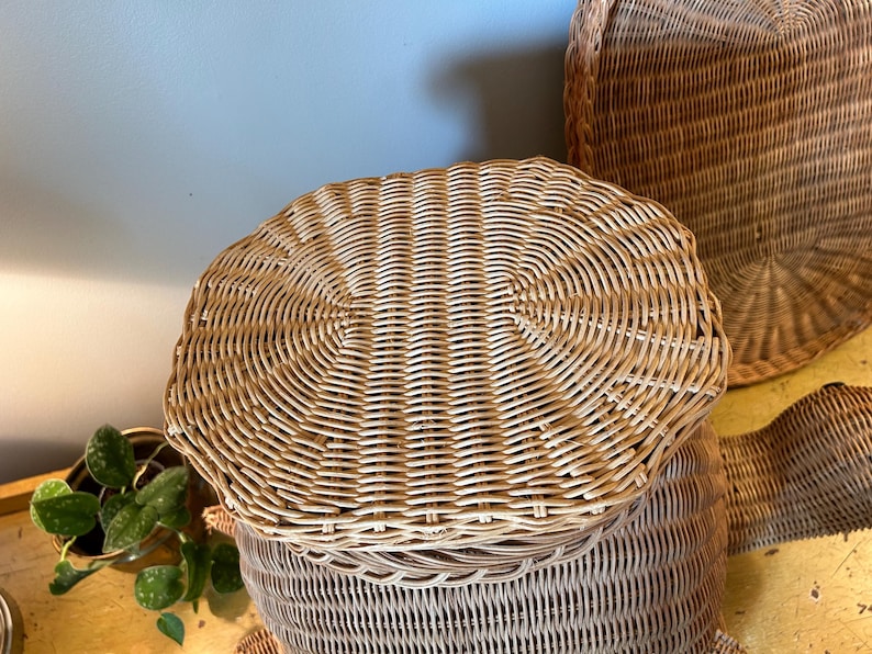 May include: A collection of woven wicker baskets in various sizes and shapes. The baskets are light brown and have a natural, textured appearance. The image showcases the intricate weaving patterns and the overall rustic aesthetic.