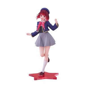 May include: An anime figurine with red hair, wearing a blue and gold uniform with a red bow. The figurine is standing on a red star-shaped base.