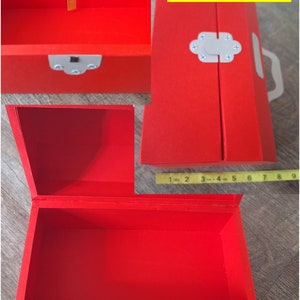 K&ouml;nnte beinhalten: Eine rote, rechteckige Box mit einem Scharnierdeckel und einem wei&szlig;en Verschluss. Die Box ist ge&ouml;ffnet und das Innere ist leer. Die Box ist mit "LARGE" beschriftet.