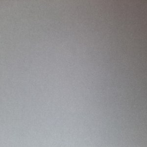 K&ouml;nnte beinhalten: Ein Blatt graues Kartonpapier mit einer dezenten strukturierten Oberfl&auml;che.