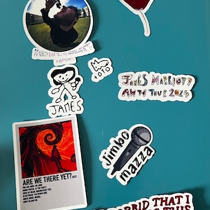 Könnte beinhalten: Eine Sammlung von Aufklebern mit verschiedenen Designs, darunter ein rotes Herz mit Augen, eine Cartoon-Strichfigur, ein Mikrofon und ein Poster mit dem Text "Are We There Yet? 2023".