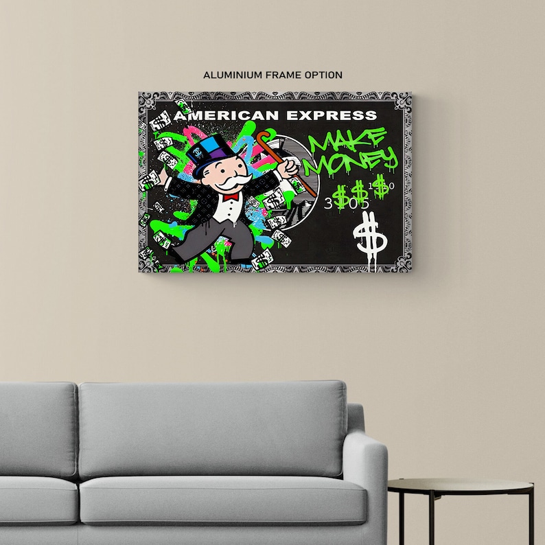 May include: A framed artwork featuring a Monopoly-inspired design with the text "AMERICAN EXPRESS" and "MAKE MONEY." The artwork depicts a Monopoly character with a top hat and cane, surrounded by dollar signs and graffiti-style accents in green and blue.