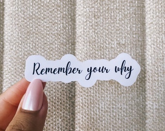 Può includere: Etichetta bianca con il testo "Remember your why" scritto in corsivo nero.
