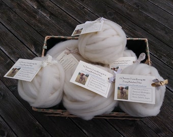 May include: A wicker basket filled with five balls of white fluffy roving yarn. Each ball has a small tag attached with the text "2 Ounces Tunis Roving $8 Pawy Brisches Fiber" and a small image of a dog.
