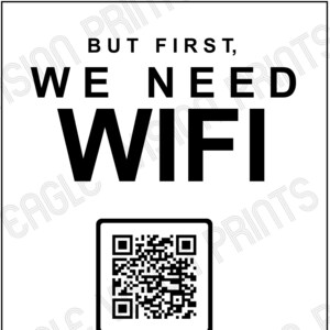 May include: A white sign with black text that reads "BUT FIRST, WE NEED WIFI." Below the text is a QR code with the words "SCAN ME." At the bottom, it says "NETWORK: YOUR NETWORK PASSWORD: YOUR PASSWORD."