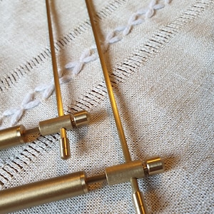 May include: Two gold metal curtain rods with a decorative end cap. The rods are adjustable and can be used for a variety of window sizes.