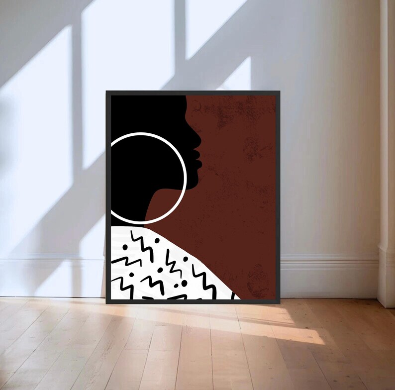 Pu&ograve; includere: Una stampa d'arte digitale che presenta una silhouette marrone e nera di un viso con un grande orecchino circolare bianco. Lo sfondo &egrave; di colore marrone testurizzato con un motivo geometrico bianco nella parte inferiore.