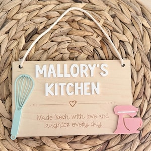 Wooden sign personalized with “Mallory’s Kitchen” laser engraved with made fresh with love and laughter every day.