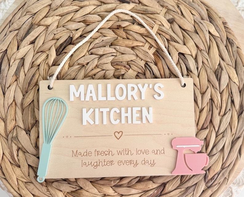 Wooden sign personalized with “Mallory’s Kitchen” laser engraved with made fresh with love and laughter every day.