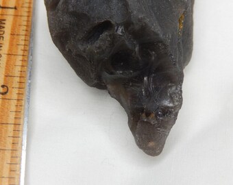 Meteorite obsidian tektite with naturally occurring skull face