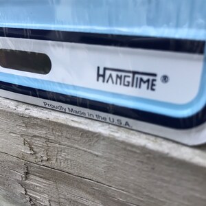 May include: Close-up of a blue and white sign with the text "Hangtime" and "Proudly Made in the U.S.A."