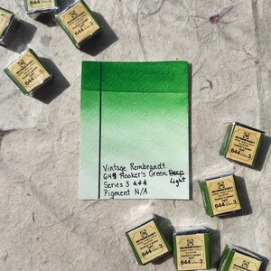 Puede incluir: Una paleta de pintura acuarela con la etiqueta "Vintage Rembrandt 644 Hooker's Green Deep Series 3 *** Pigment N/A Light" y una muestra de acuarela verde.