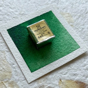 May include: A small, silver-wrapped watercolor paint pan labeled "REMBrandT artist's water colour aquarelle hooker's green deep 645 SERIES 3".