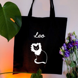 Leo star sign Astrology tote bag, Adorable cat with Lions Maine, based on Leo zodiac symbolism, on a black tote bag. Horoscope tote bag uk