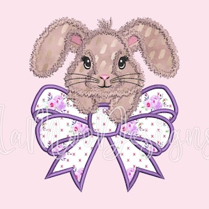 May include: A brown bunny rabbit with a purple bow. The bow has a white background with a floral pattern and a purple outline.