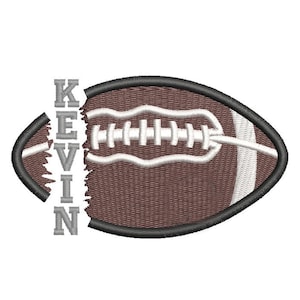 May include: Embroidered football with the name "KEVIN" in gray letters. The football is brown with white stitching and a black outline. The design is on a white background.